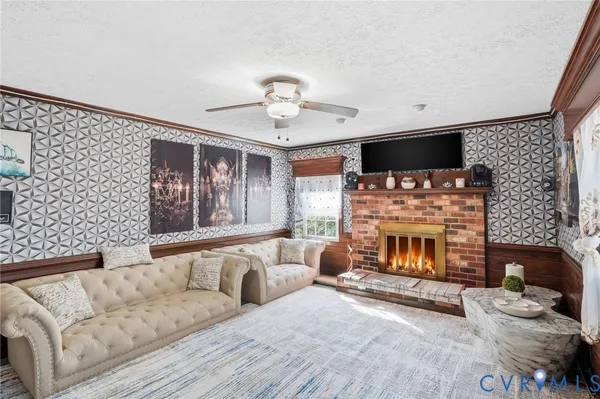 a living room with furniture a flat screen tv and a fireplace