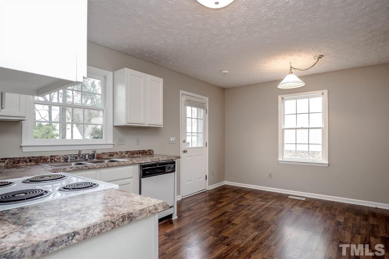 5333 Spring Pines Way Raleigh, NC 27616 - Photo 11 of 25 a kitchen with a stove a sink wooden floor and a window