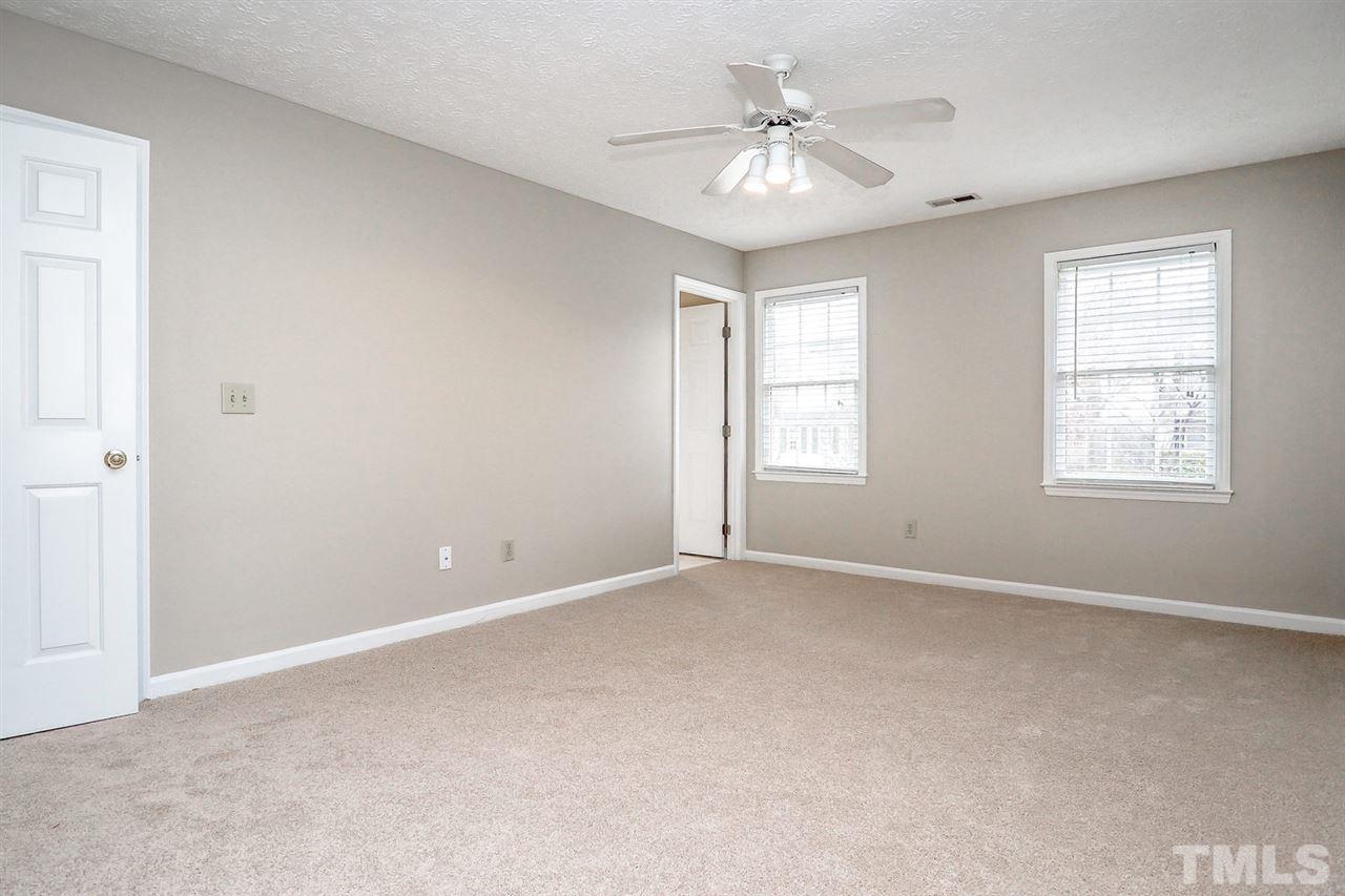 5333 Spring Pines Way Raleigh, NC 27616 - Photo 16 of 25 an empty room with windows and chandelier fan
