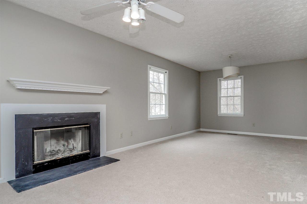 5333 Spring Pines Way Raleigh, NC 27616 - Photo 5 of 25 a view of an empty room with chandelier fan and fireplace