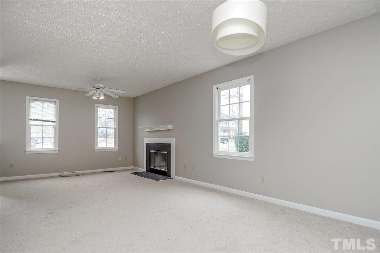 5333 Spring Pines Way Raleigh, NC 27616 - Photo 7 of 25 an empty room with a fireplace and windows