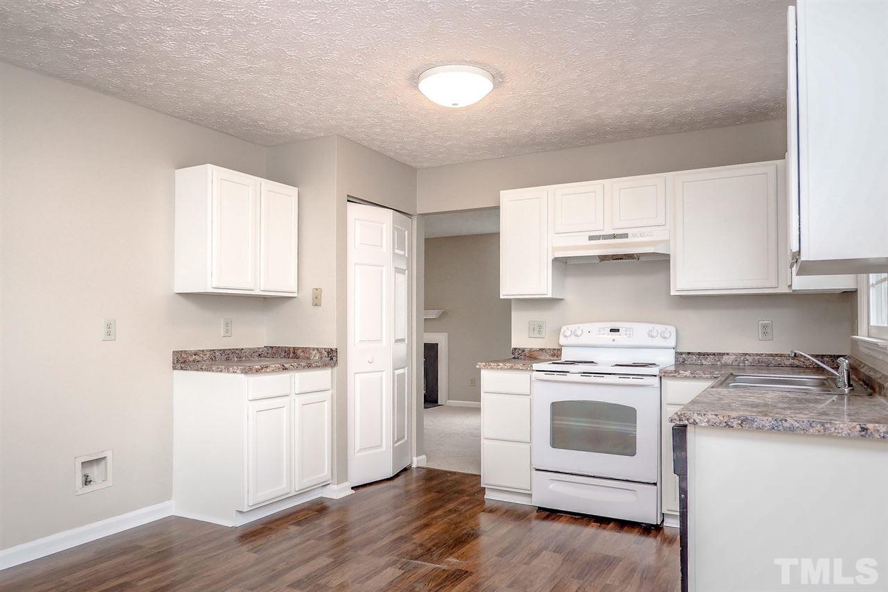 5333 Spring Pines Way Raleigh, NC 27616 - Photo 10 of 25 a kitchen with white cabinets and white appliances