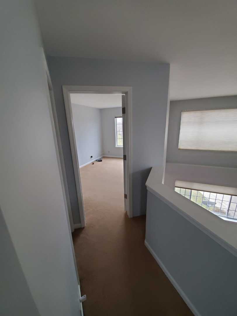 5451 Elizabeth Place Rolling Meadows, IL 60008 - Photo 17 of 34 a view of a hallway to a room with wooden floor and staircase