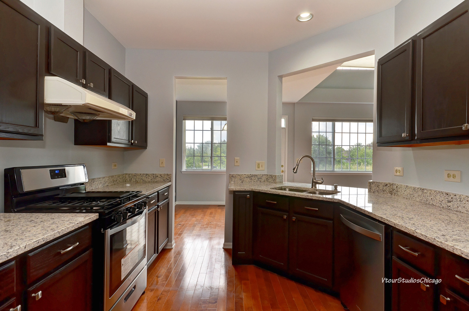 5451 Elizabeth Place Rolling Meadows, IL 60008 - Photo 7 of 34 a kitchen with stainless steel appliances a sink dishwasher a stove top oven a refrigerator with wooden floors and granite countertops