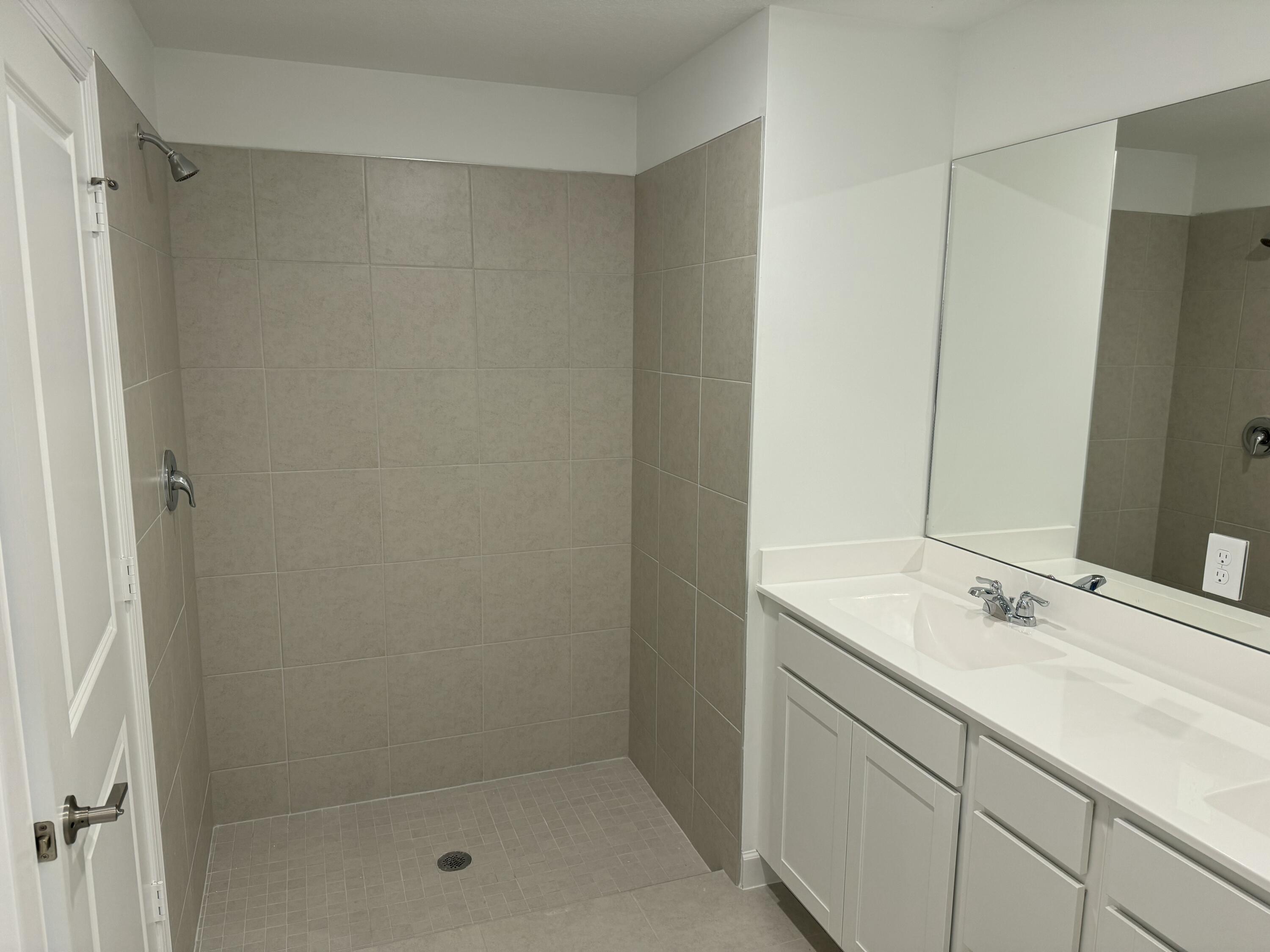 10501 Northwest Suncrest Loop Port St. Lucie, FL 34987 - Photo 13 of 33 a bathroom with a shower sink and vanity