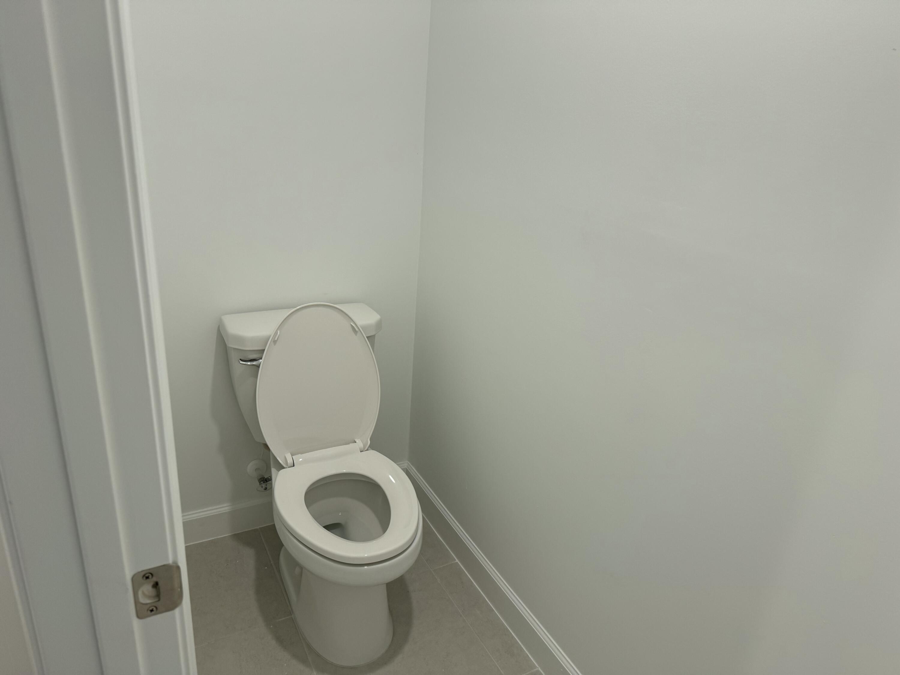 10501 Northwest Suncrest Loop Port St. Lucie, FL 34987 - Photo 14 of 33 a white toilet sitting in a bathroom