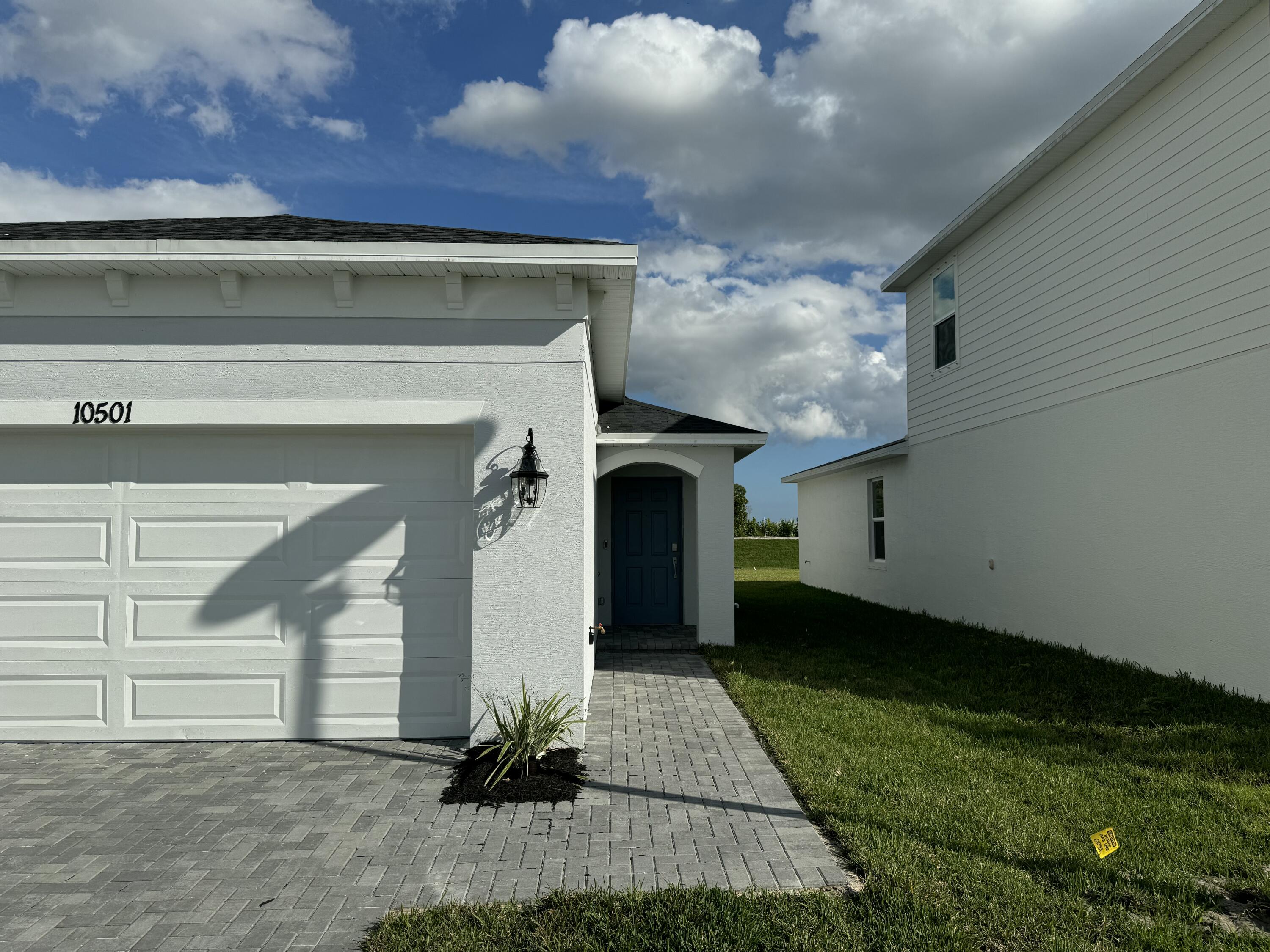 10501 Northwest Suncrest Loop Port St. Lucie, FL 34987 - Photo 3 of 33 a front view of a house with a yard