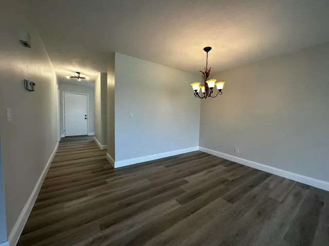 a view of a livingroom with wooden floor a chandelier