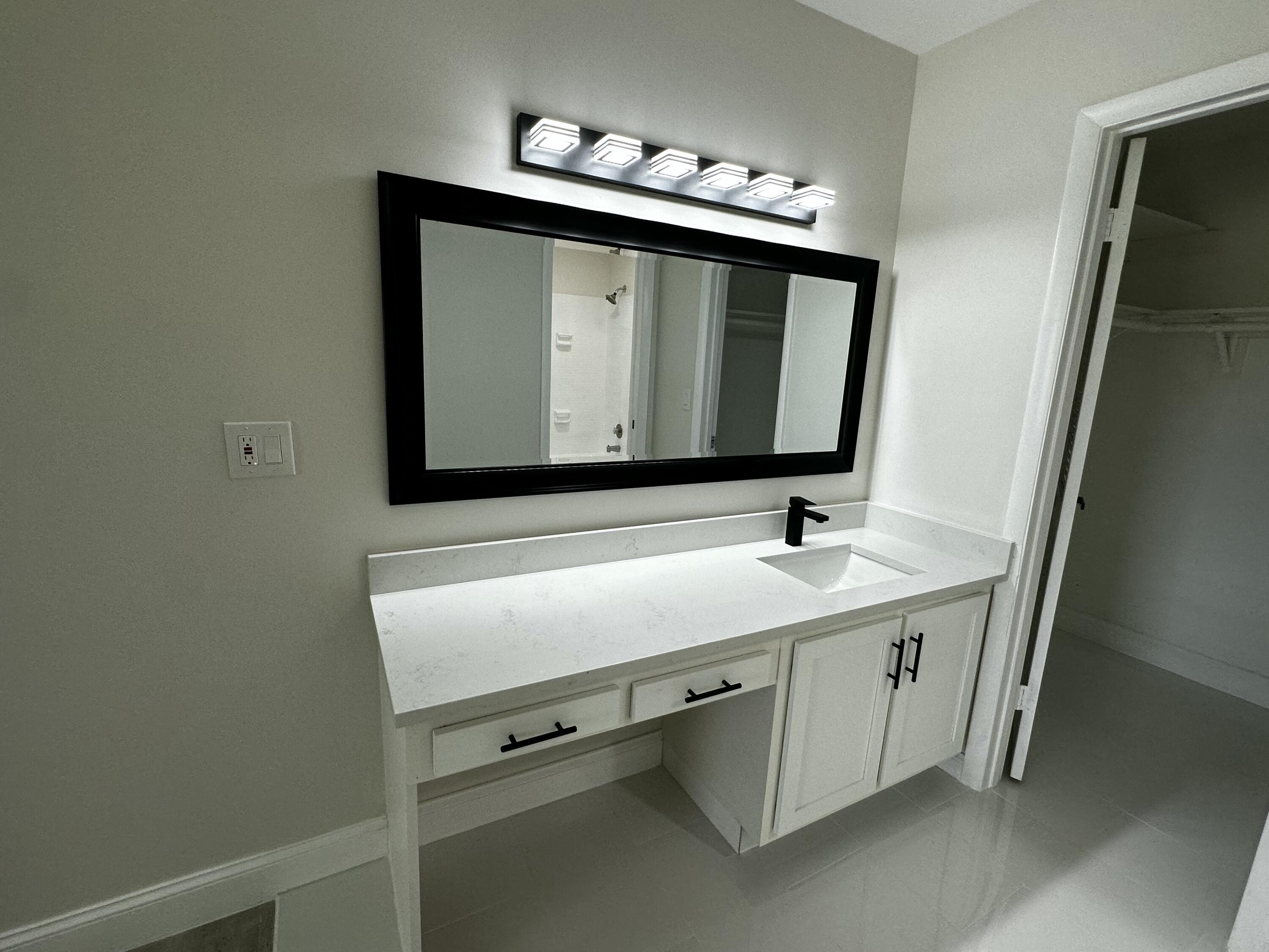 13682 Vía Flora, Unit H Delray Beach, FL 33484 - Photo 22 of 28 a bathroom with a sink and a mirror