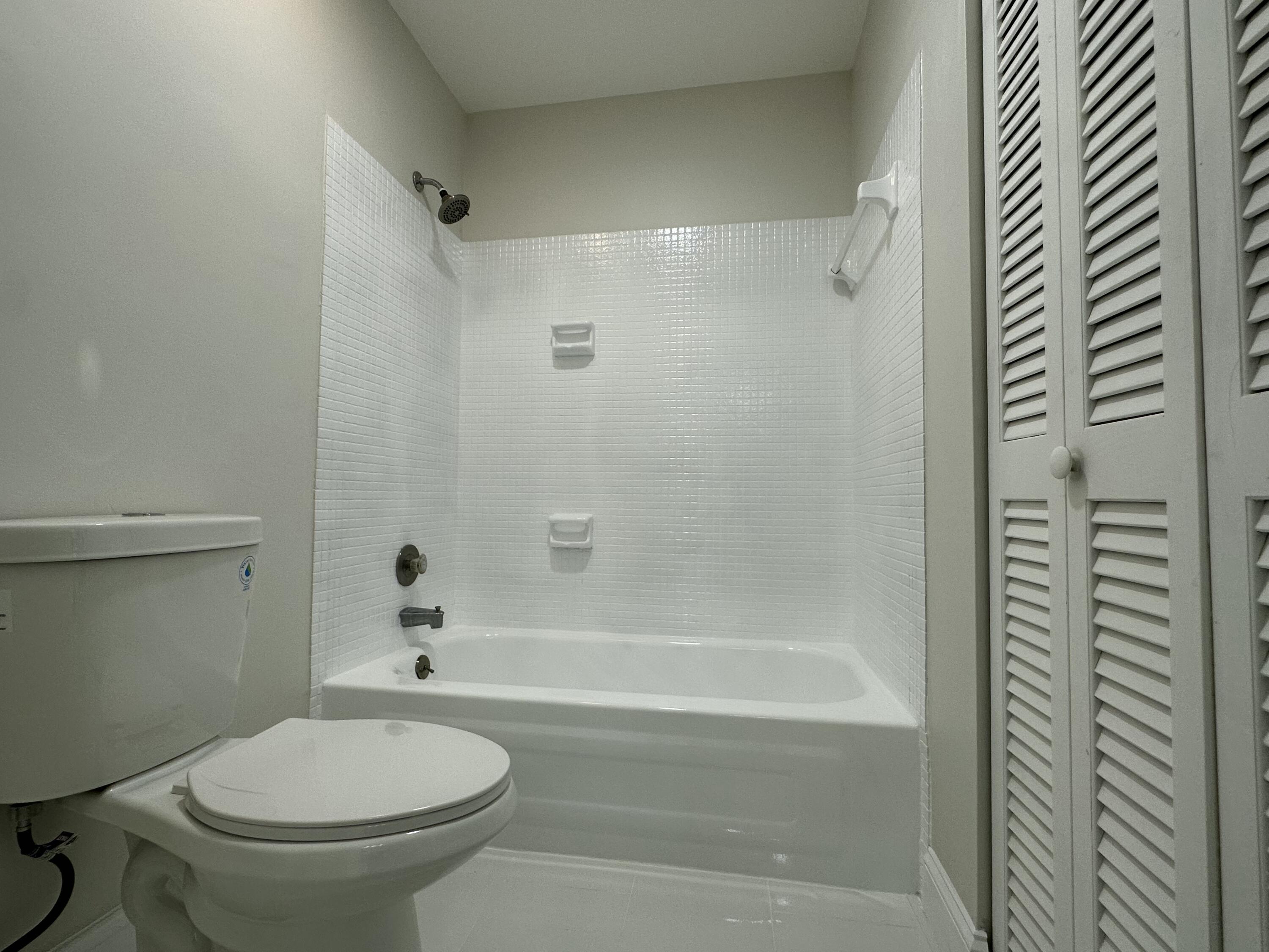 13682 Vía Flora, Unit H Delray Beach, FL 33484 - Photo 23 of 28 a bathroom with a toilet and a bathtub