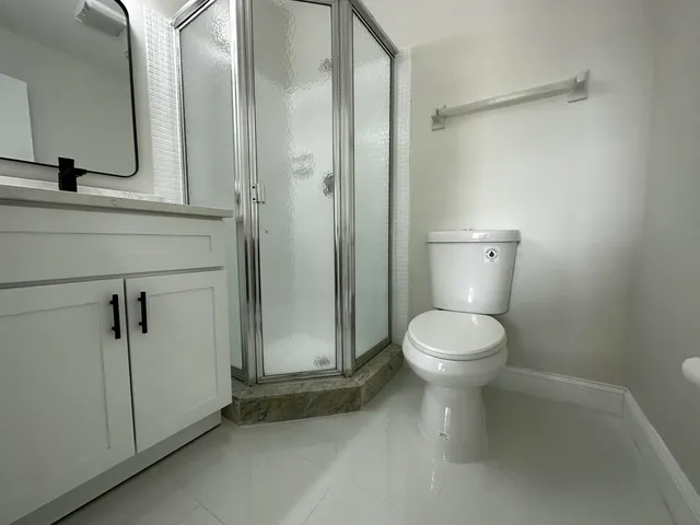 a bathroom with a toilet a sink and shower