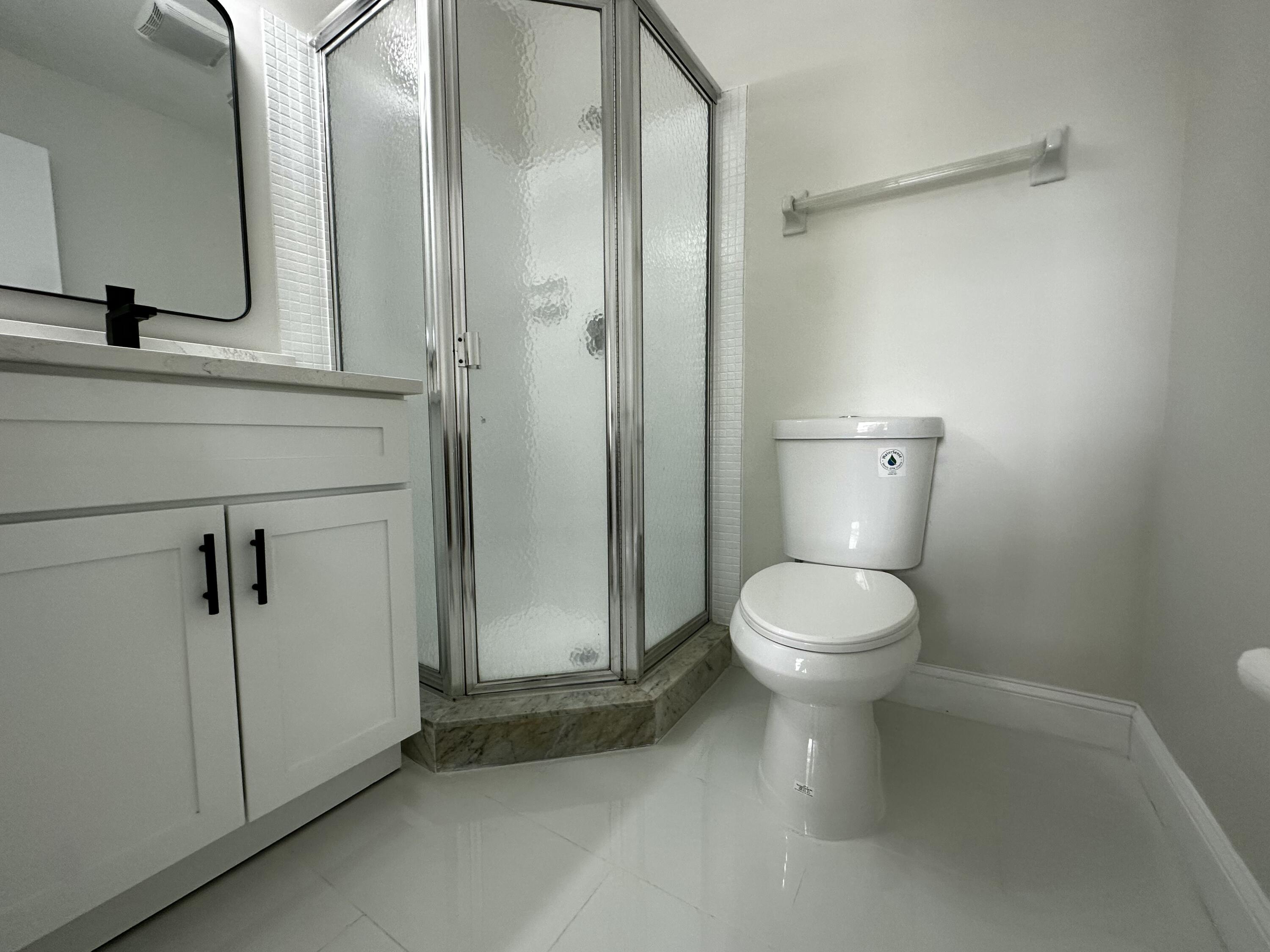 13682 Vía Flora, Unit H Delray Beach, FL 33484 - Photo 28 of 28 a bathroom with a toilet a sink and shower