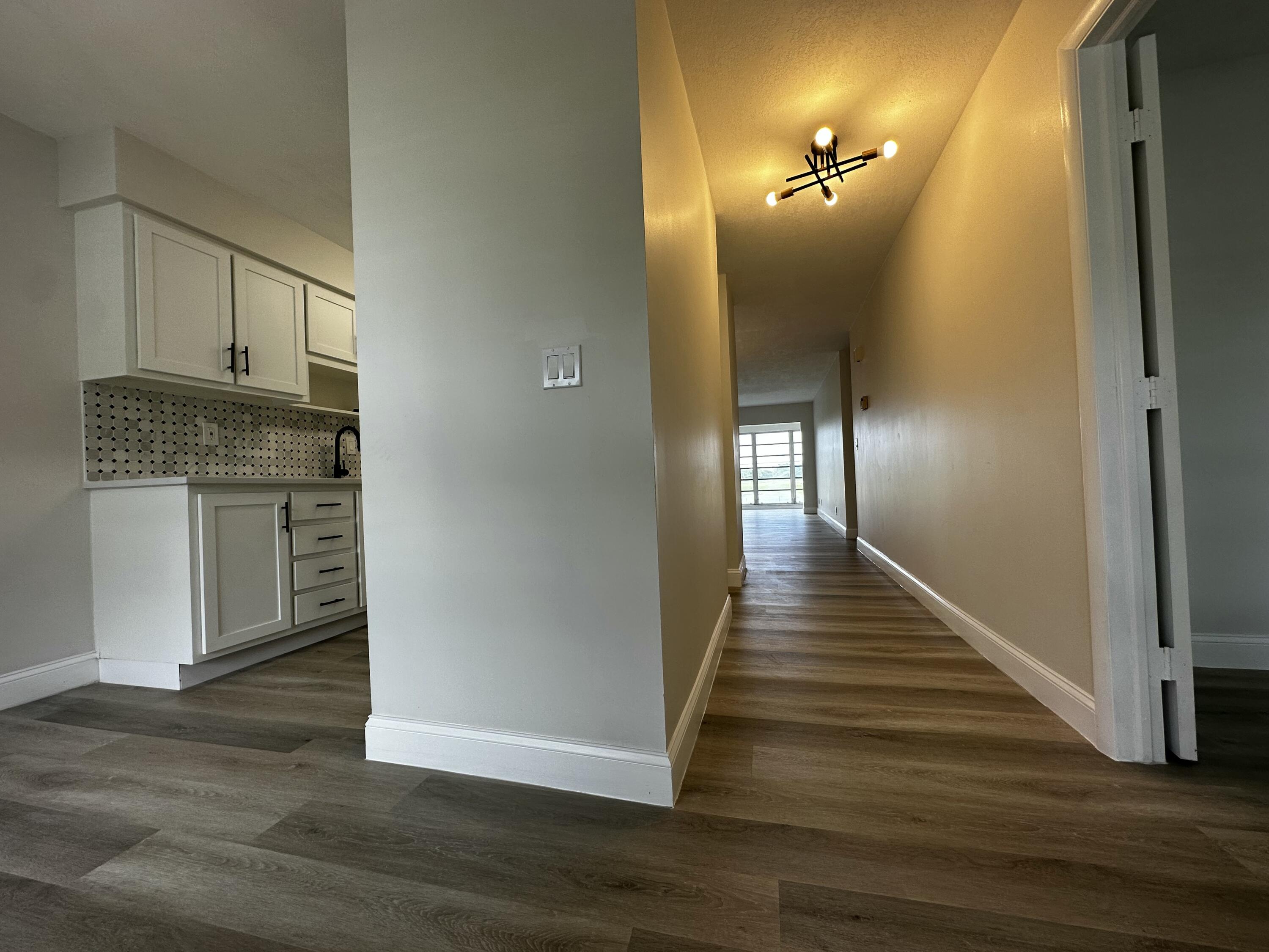 13682 Vía Flora, Unit H Delray Beach, FL 33484 - Photo 3 of 28 a view of a hallway with wooden floor and staircase