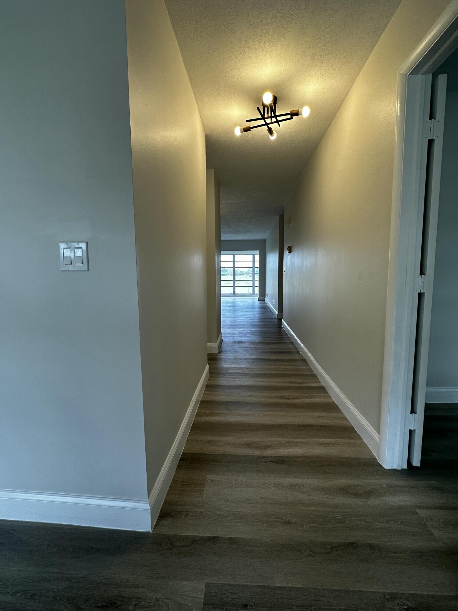 13682 Vía Flora, Unit H Delray Beach, FL 33484 - Photo 4 of 28 a view of a hallway with wooden floor and staircase