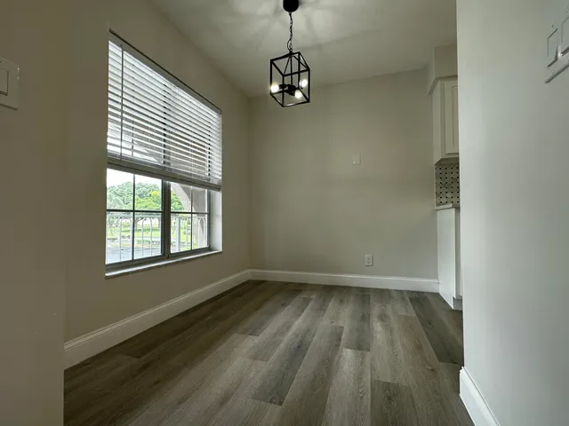 a view of a room with wooden floor and a window