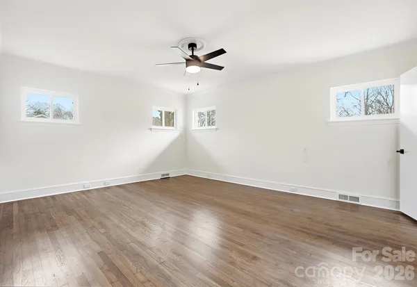 a view of an empty room with wooden floor