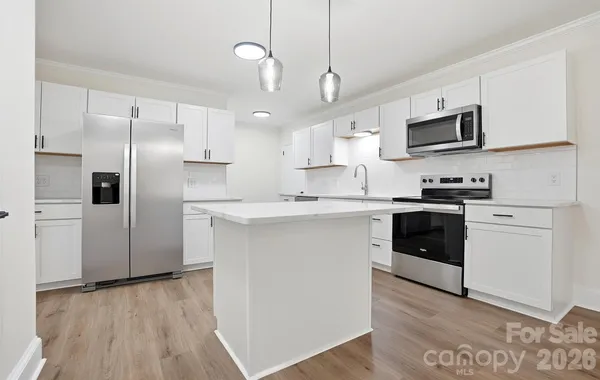 a kitchen with stainless steel appliances a refrigerator sink and microwave