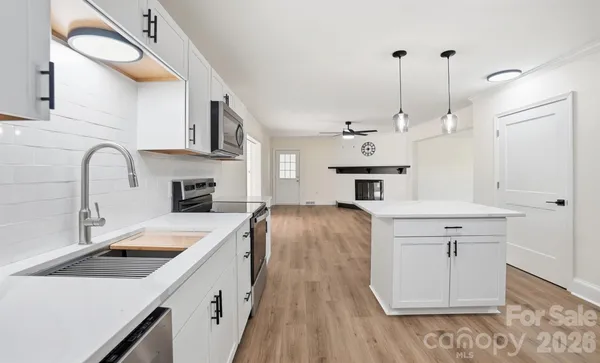 a kitchen with a sink a stove and cabinets