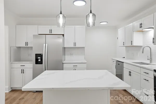 a kitchen with a refrigerator a sink and cabinets