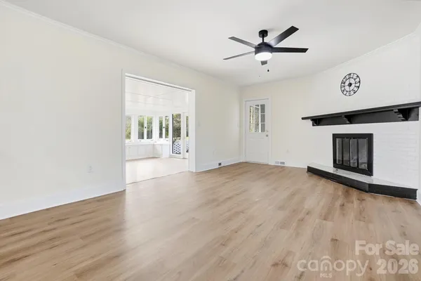 an empty room with wooden floor and fireplace
