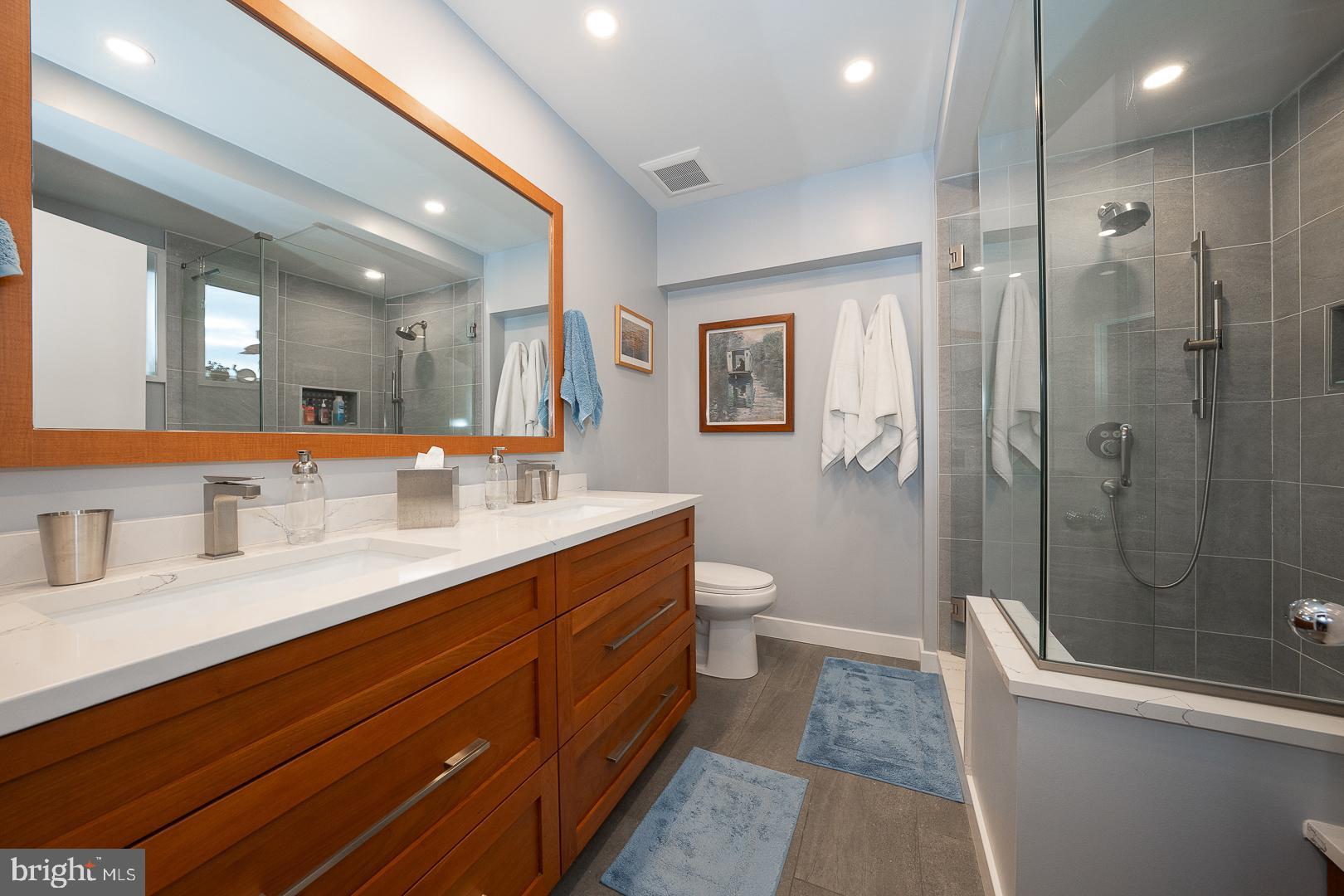 1900 Hamilton Street, Unit D19 Philadelphia, PA 19130 - Photo 19 of 36 a spacious bathroom with a double vanity sink toilet mirror and shower