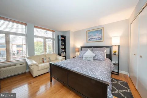 a spacious bedroom with a bed and a couch with large window