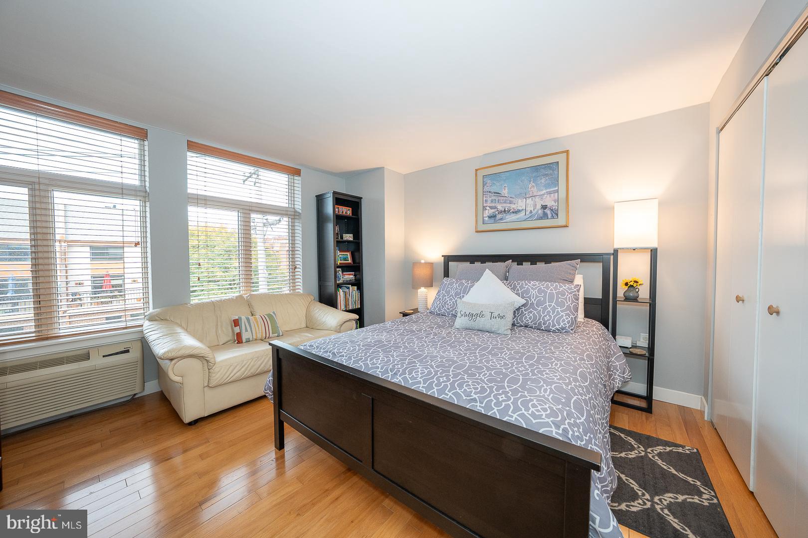 1900 Hamilton Street, Unit D19 Philadelphia, PA 19130 - Photo 21 of 36 a spacious bedroom with a bed and a couch with large window