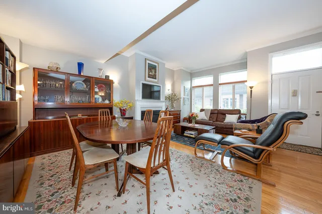 a living room with furniture a flat screen tv and a dining table