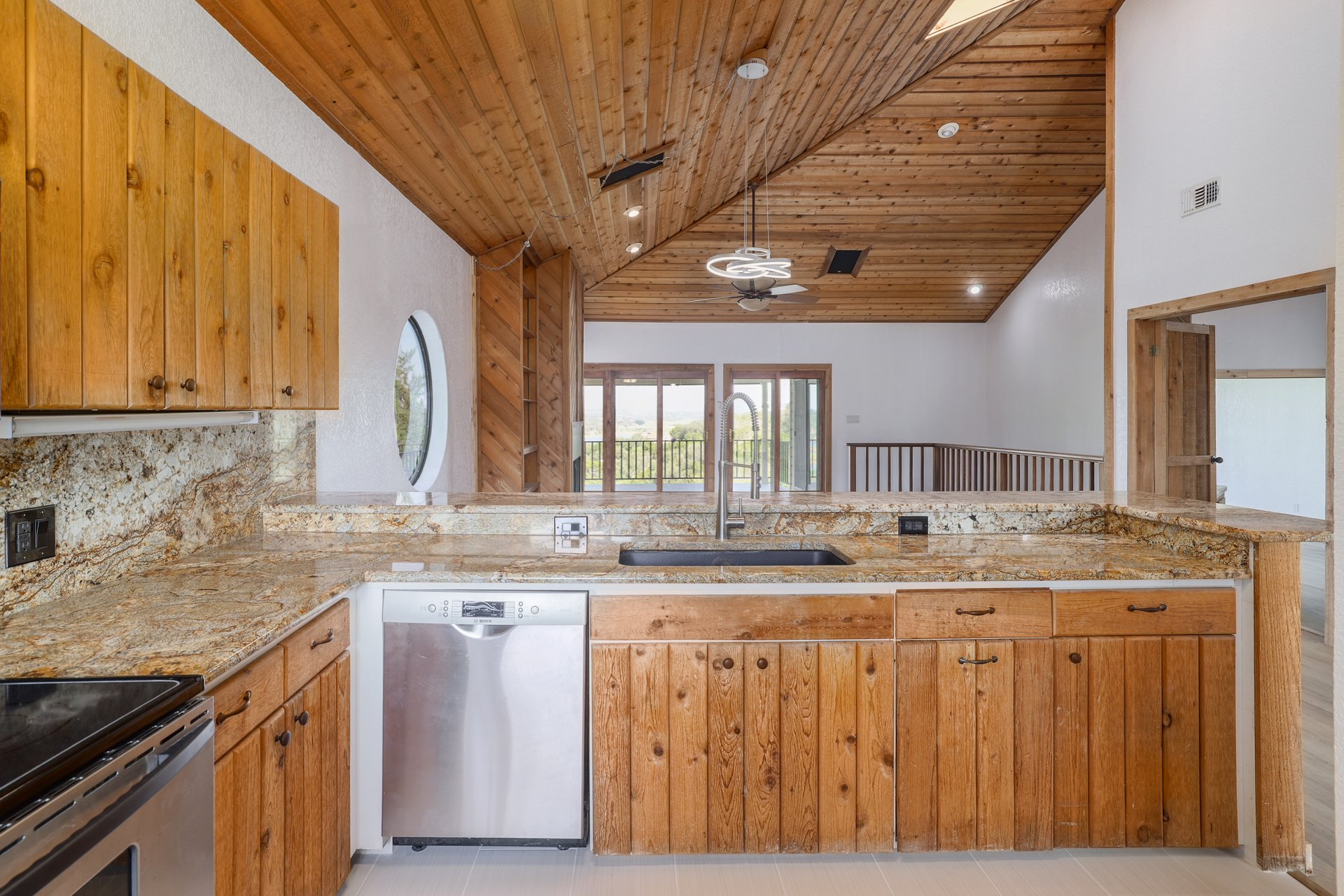 313 Kendall Road Spicewood, TX 78669 - Photo 7 of 34 Kitchen with hanging light fixtures, appliances with stainless steel finishes, wood ceiling, tasteful backsplash, and high vaulted ceiling