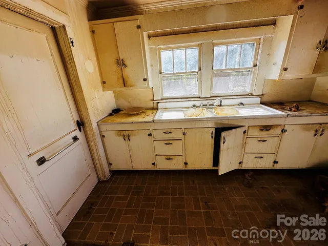 a view of a kitchen with a sink stainless steel appliances and a window