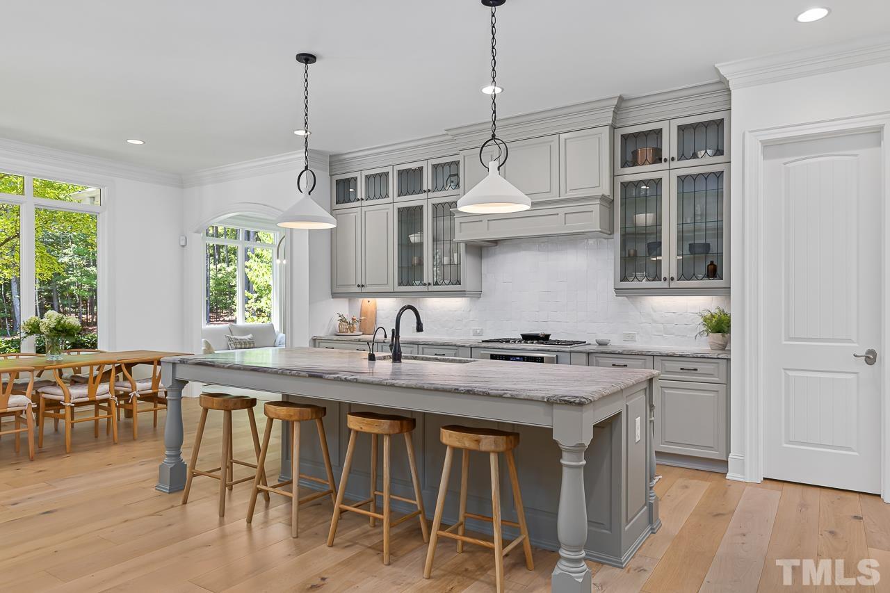 18 Crimson Oak Drive Durham, NC 27713 - Photo 12 of 87 a kitchen with stainless steel appliances granite countertop a stove a refrigerator a sink a dining table and chairs with wooden floor