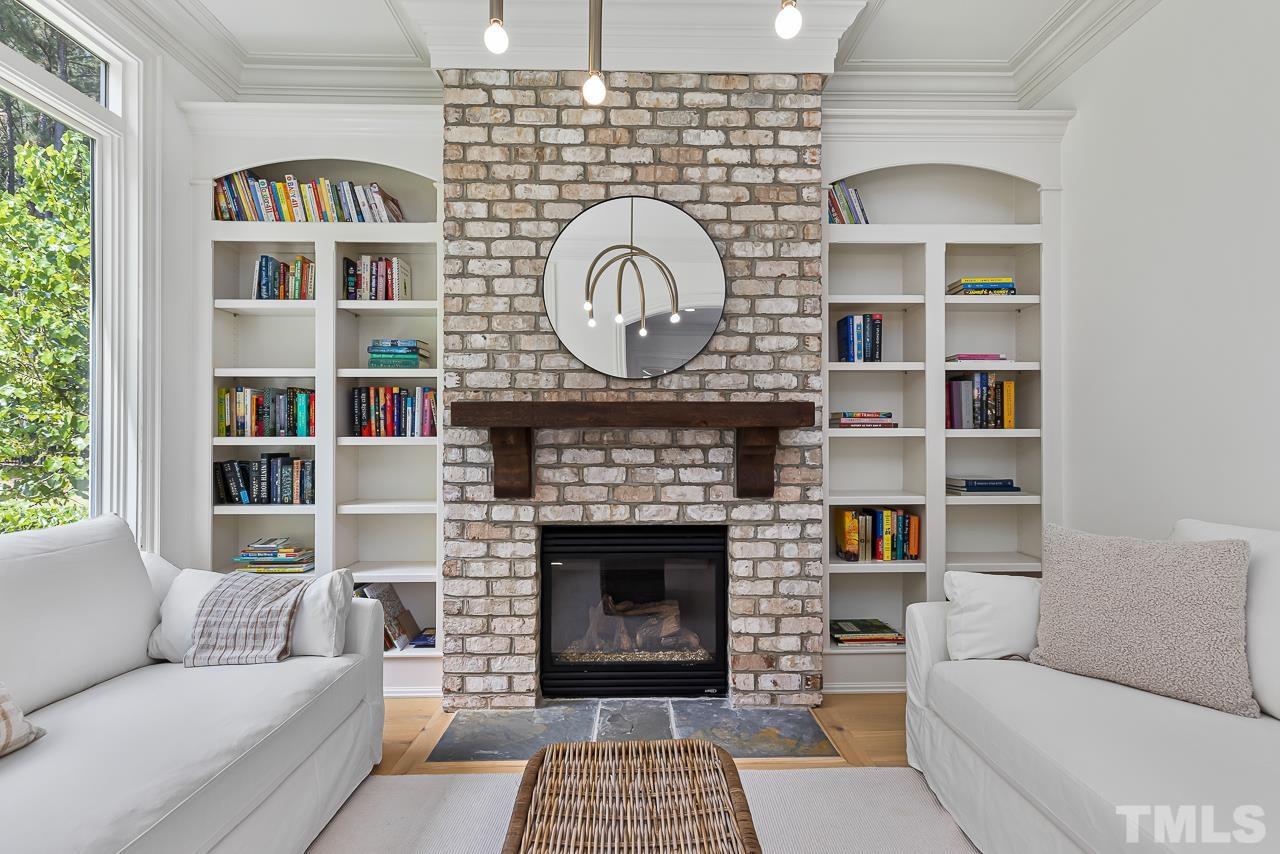 18 Crimson Oak Drive Durham, NC 27713 - Photo 27 of 87 a living room with furniture a fireplace and a book shelf