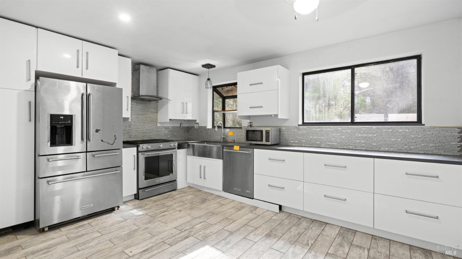 11144 Ice Box Canyon Road Forestville, CA 95436 - Photo 13 of 38 a kitchen with granite countertop white cabinets and stainless steel appliances
