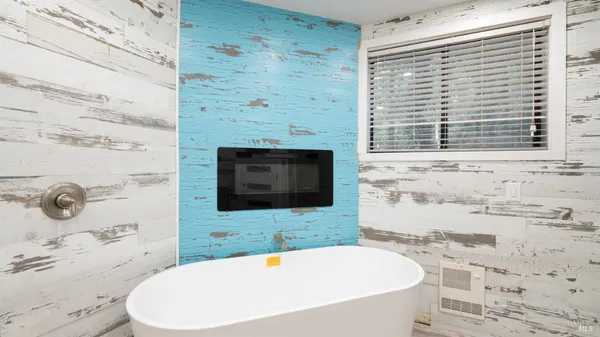 a bathroom with a tub a sink and a window