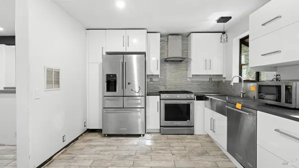 a kitchen with stainless steel appliances a refrigerator sink and microwave