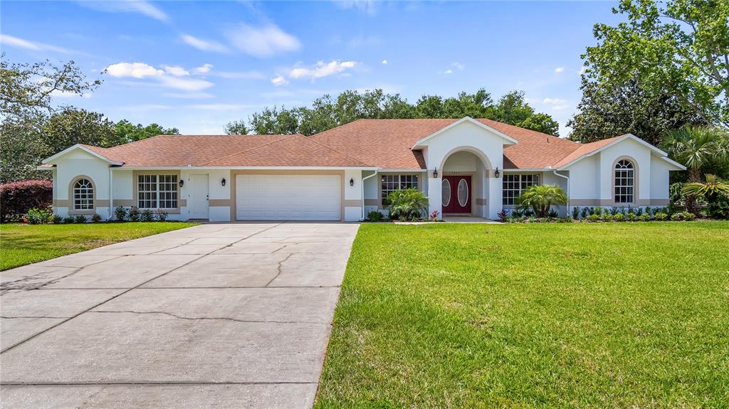 a front view of a house with yard and green space