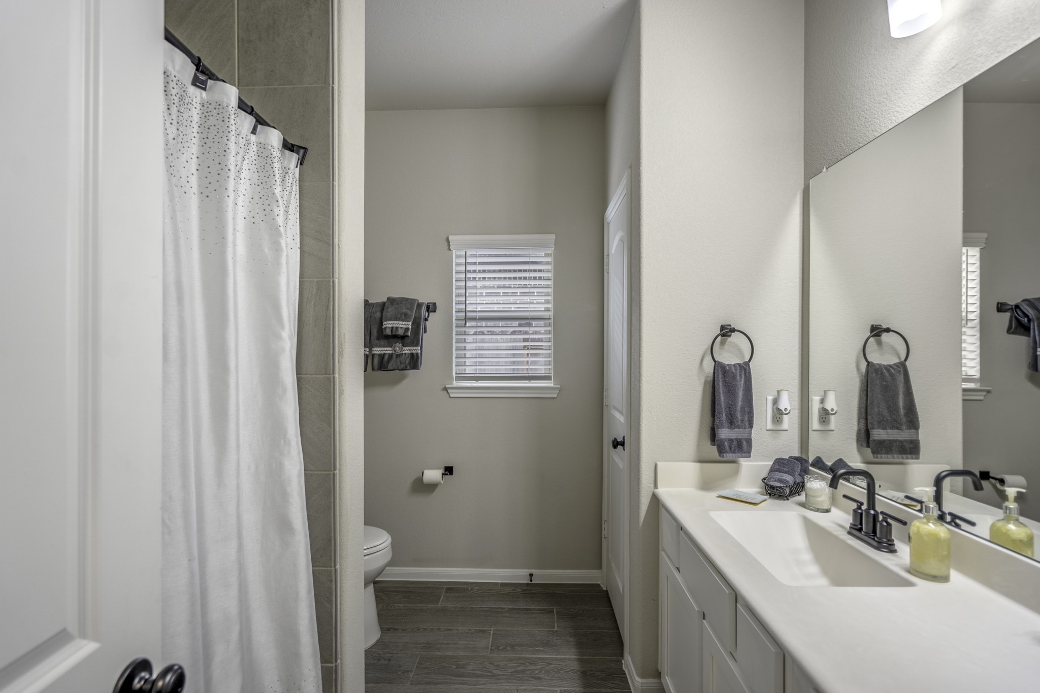 30391 Limber Pines Drive Magnolia, TX 77355 - Photo 12 of 49 This inviting shared bathroom boasts modern fixtures, a sleek vanity, and ample natural light, creating a bright and functional space for any home.