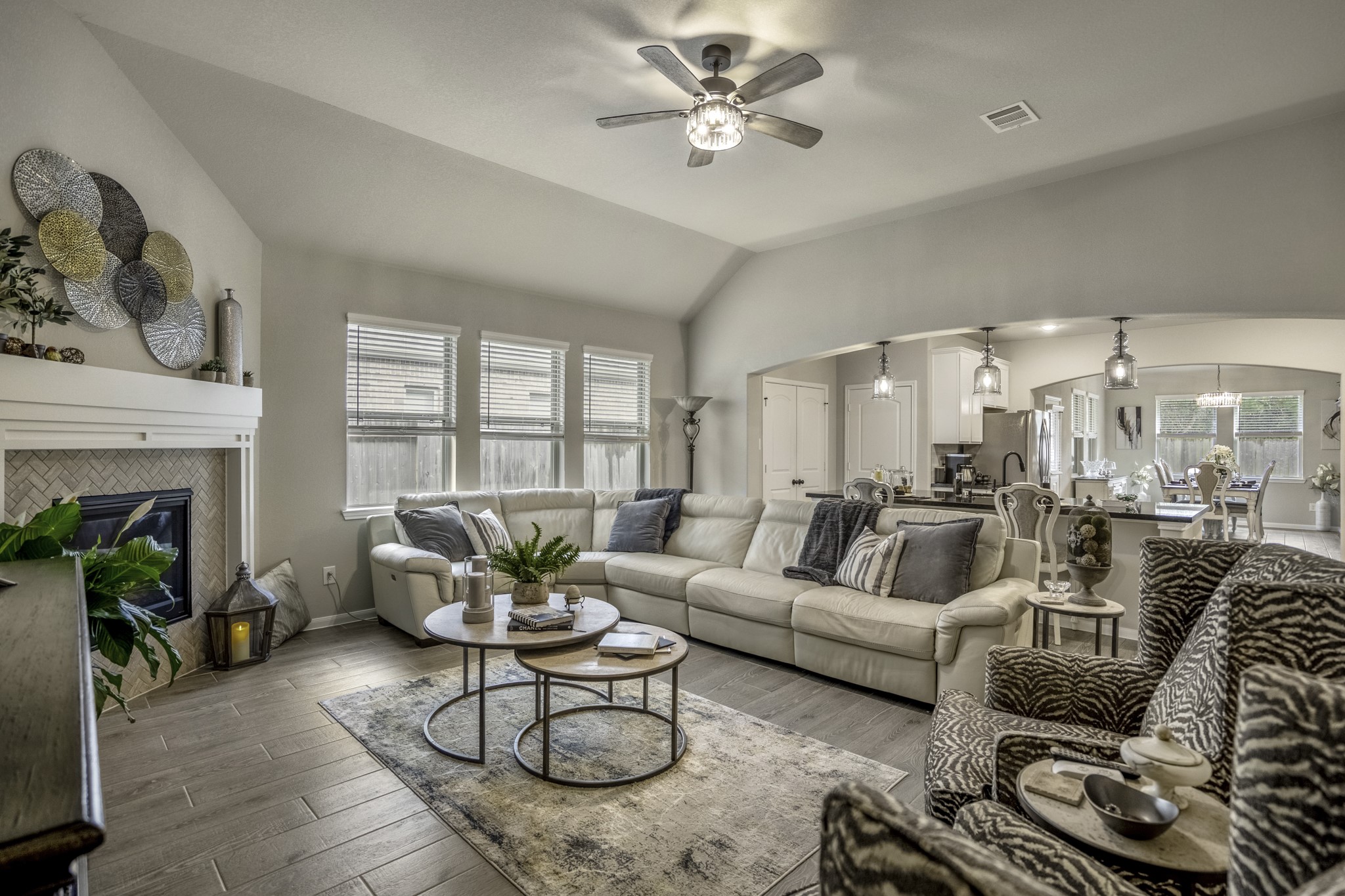 30391 Limber Pines Drive Magnolia, TX 77355 - Photo 18 of 49 Discover the perfect blend of comfort and style in this home's inviting open-concept living area, seamlessly connecting the cozy fireplace-lit lounge to a modern kitchen and dining space, ideal for both relaxing and entertaining.