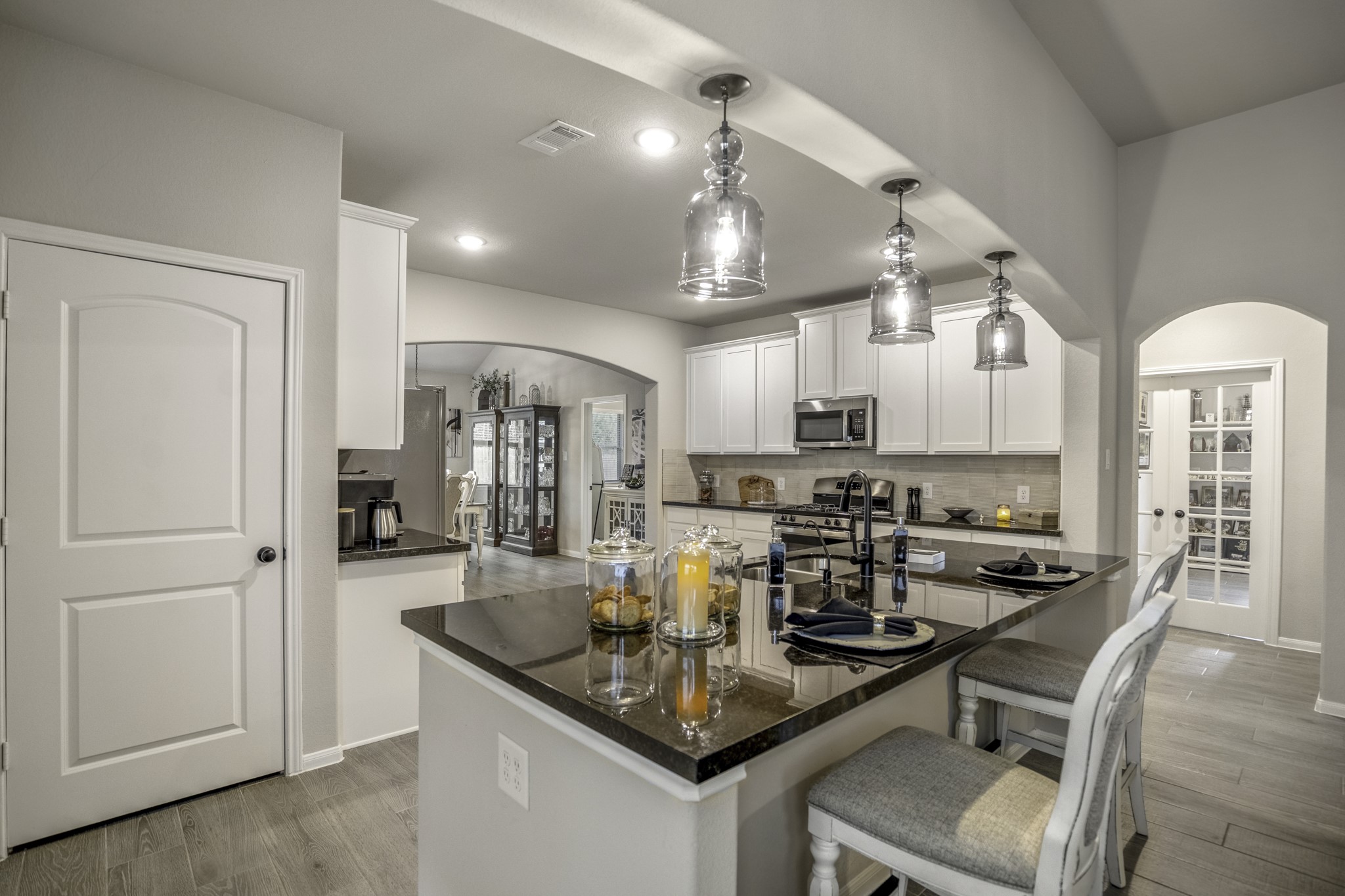 30391 Limber Pines Drive Magnolia, TX 77355 - Photo 21 of 49 This modern kitchen features a sleek eat-at island perfect for casual dining and entertaining, complemented by stylish lighting and ample cabinetry.