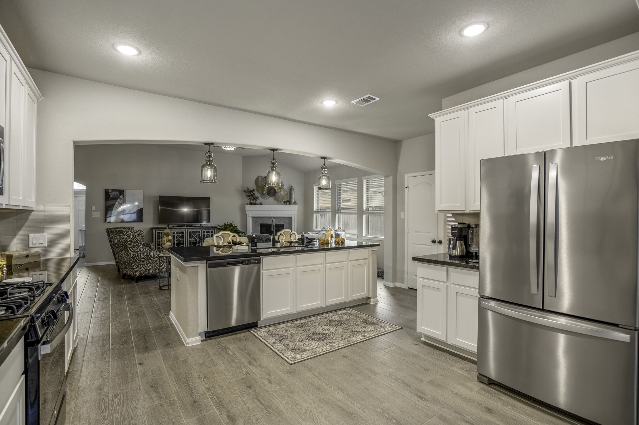 30391 Limber Pines Drive Magnolia, TX 77355 - Photo 23 of 49 Discover a modern kitchen with sleek stainless steel appliances, seamlessly flowing into a bright, open living area, perfect for entertaining and everyday living.