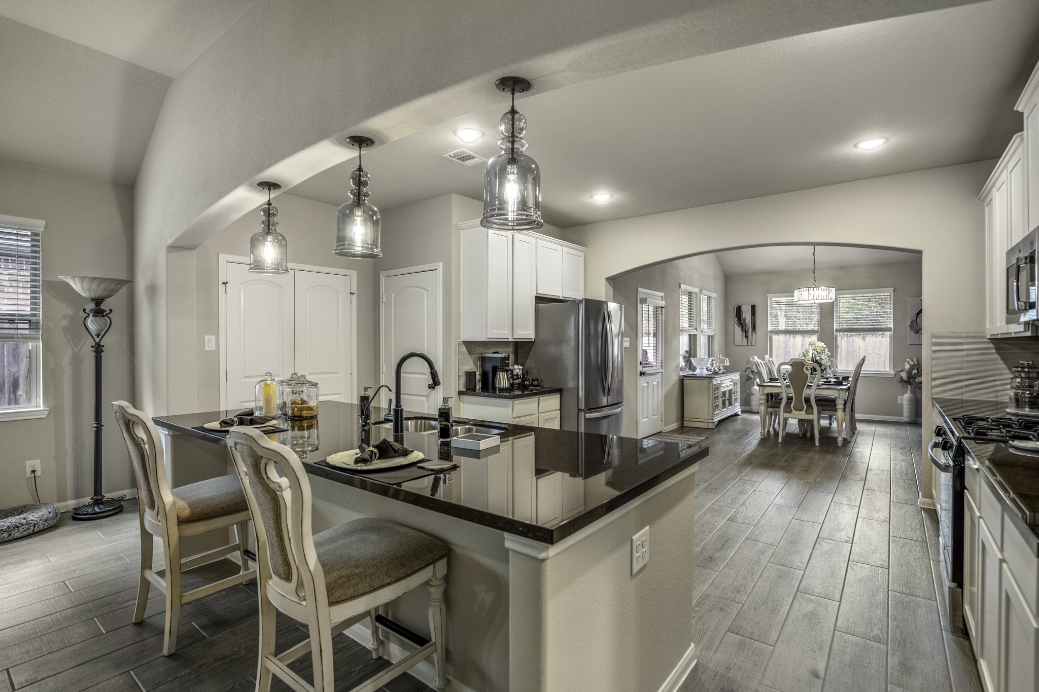 30391 Limber Pines Drive Magnolia, TX 77355 - Photo 4 of 49 Discover a seamless blend of elegance and modernity in this home, featuring a spacious kitchen with sleek countertops, stylish pendant lighting, and an inviting dining area perfect for entertaining.