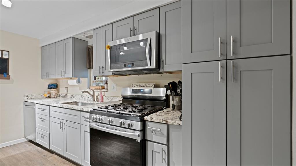 300 Sunset Boulevard Washington, PA 15301 - Photo 10 of 38 a kitchen with stainless steel appliances granite countertop a stove a microwave and a refrigerator