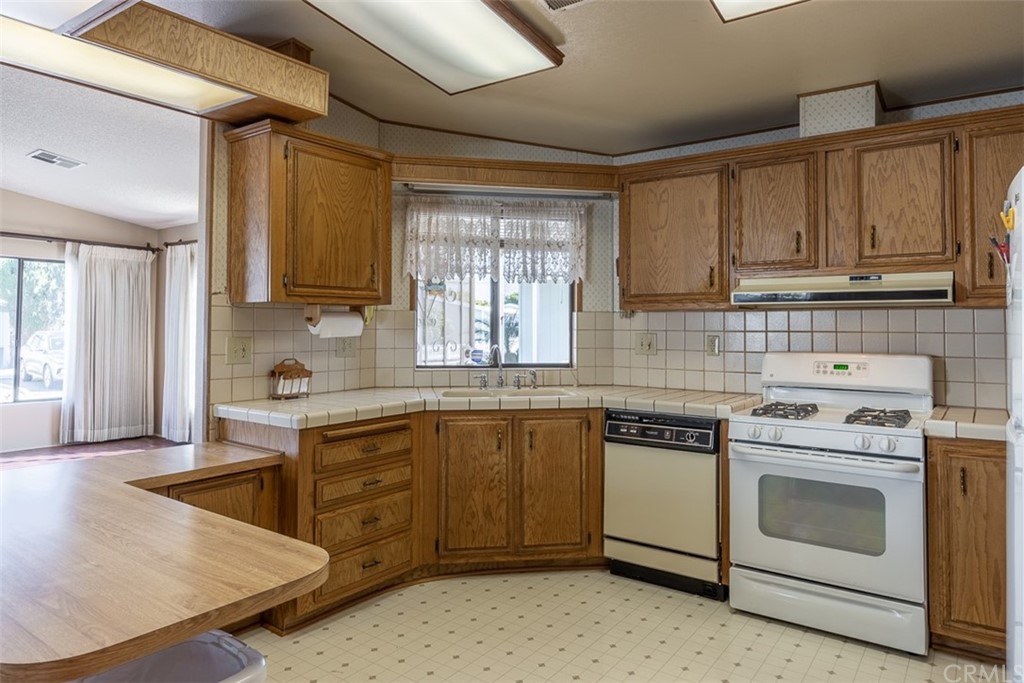 24600 Mountain Avenue, Unit 57 Hemet, CA 92544 - Photo 7 of 20 a kitchen with granite countertop cabinets stainless steel appliances and a sink