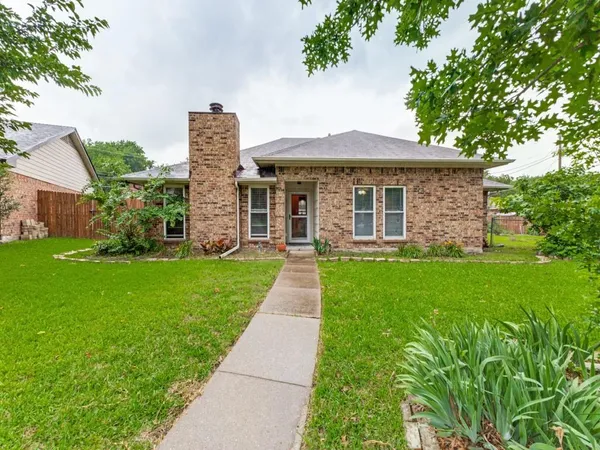 a front view of a house with a yard and garden