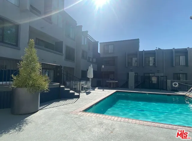 a swimming pool with barbeque oven in front of it