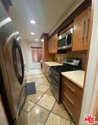 a kitchen with granite countertop a stove a sink and a microwave