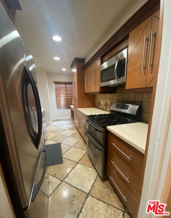 1940 North Highland Avenue, Unit 44 Los Angeles, CA 90068 - Photo 5 of 10 a kitchen with granite countertop a stove a sink and a microwave