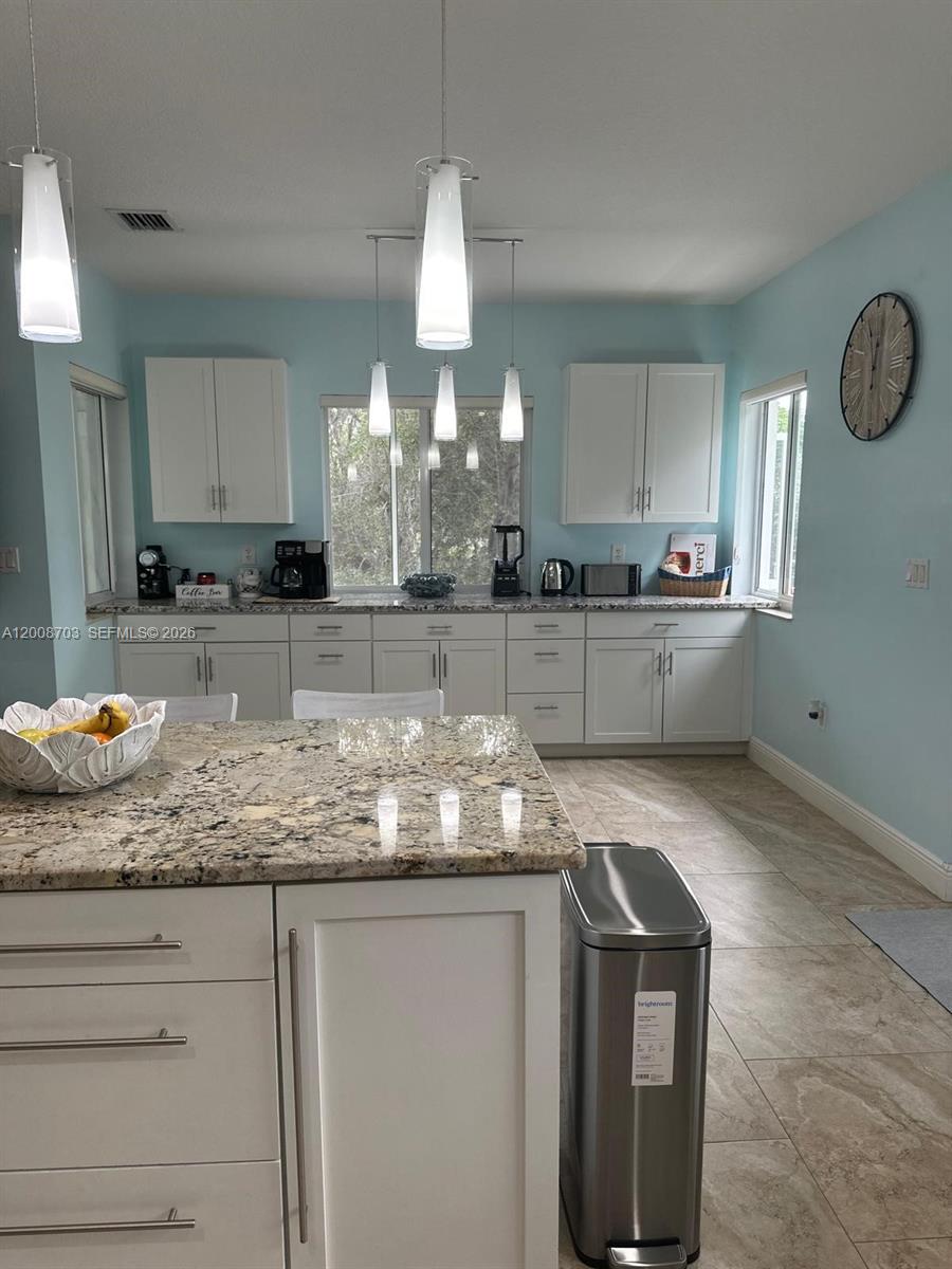 1019 Snapper Lane Key Largo, FL 33037 - Photo 21 of 37 a kitchen with granite countertop white cabinets and stainless steel appliances