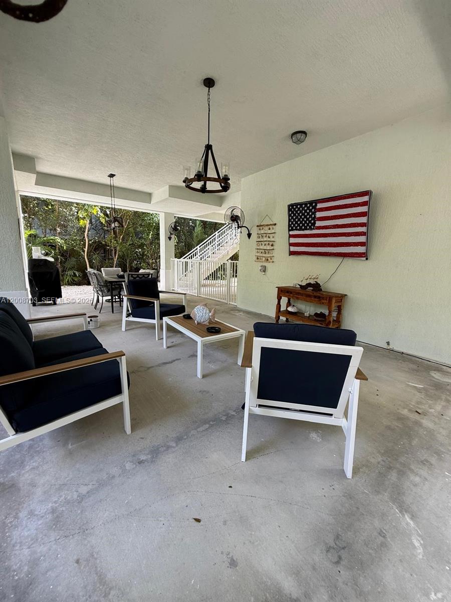 1019 Snapper Lane Key Largo, FL 33037 - Photo 10 of 37 a living room with furniture and a chandelier