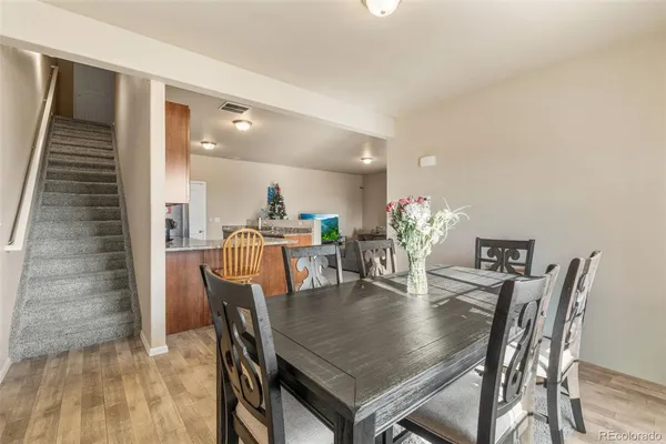 a dining room with furniture and wooden floor